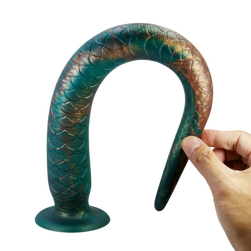 Queue Wildwyrm Tail pliée en arc complet par une main, silicone très souple