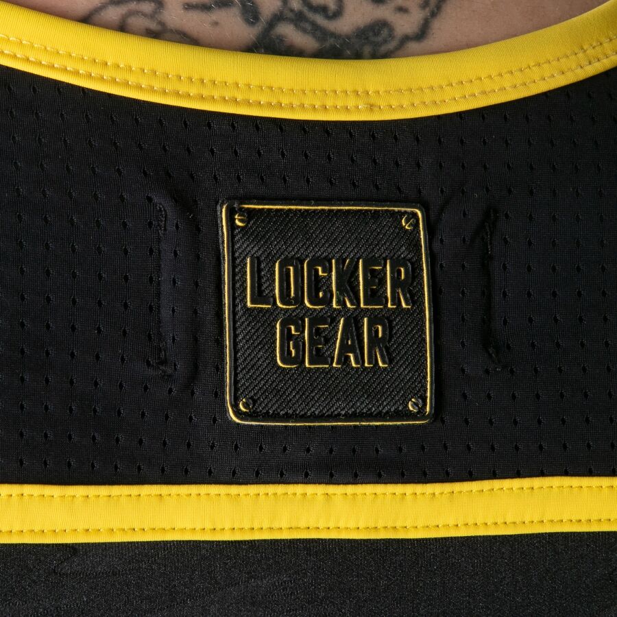 Gros plan sur le panneau perforé et le logo Locker Gear au dos du débardeur noir et jaune