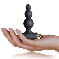 Plug anal en silicone noir tenu dans la paume de la main
