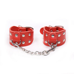 Red wrist cuffs with large rivets and metal chain