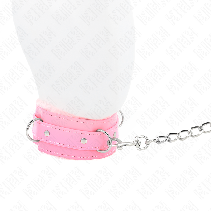 Gros plan du mousqueton de la laisse fixé à l'anneau du collier rose