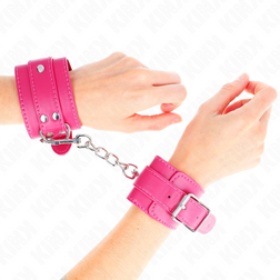 Menottes sissy rose framboise KINK portées aux poignets, reliées par une chaîne