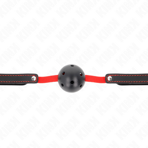 Vue de face de la boule noire creuse sur sa bande élastique rouge