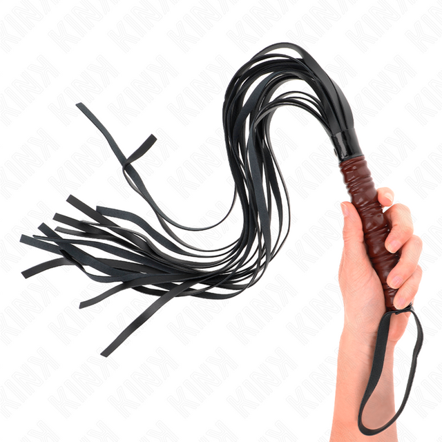 Martinet KINK tenu en main, lanières noires déployées et dragonne autour du poignet
