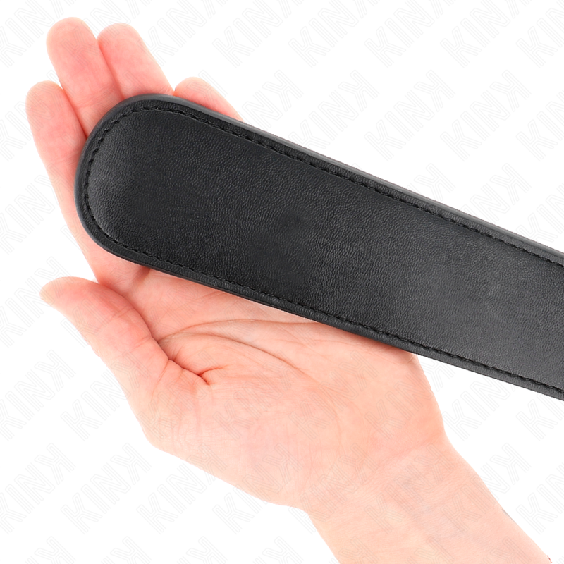 Gros plan du bout arrondi du paddle noir posé sur une paume