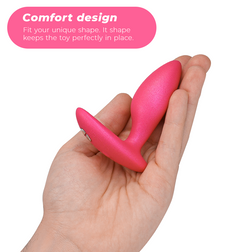 Plug anal Ditto+ rose posé dans une main, montrant son col fin et sa base flexible.