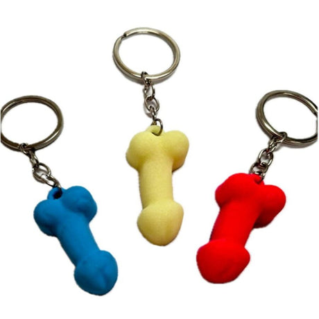 Three blue, yellow and red silicone penis keyrings on a white background.