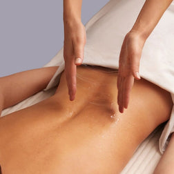 Massage gel being applied to a back for body-to-body contact
