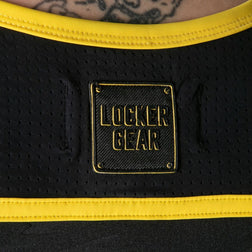 Gros plan sur le panneau perforé et le logo Locker Gear au dos du débardeur noir et jaune
