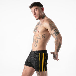 Homme portant le short noir Full Military Access à détails jaunes, vue de trois quarts