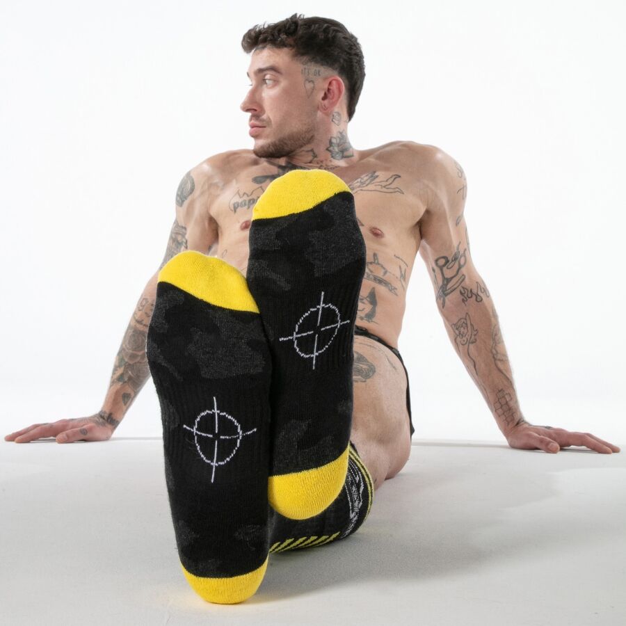 Semelles noires à pointes jaunes des chaussettes hautes Locker Gear portées