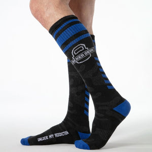 Jambes d’homme portant les chaussettes hautes noires et bleues Locker Gear, vue de profil