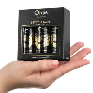 Coffret miniature Sexy Therapy ORGIE de trois huiles de 30 ml posé dans la paume d'une main