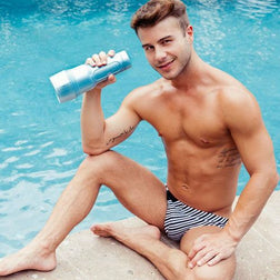Man holding his blue masturbator beside a swimming pool